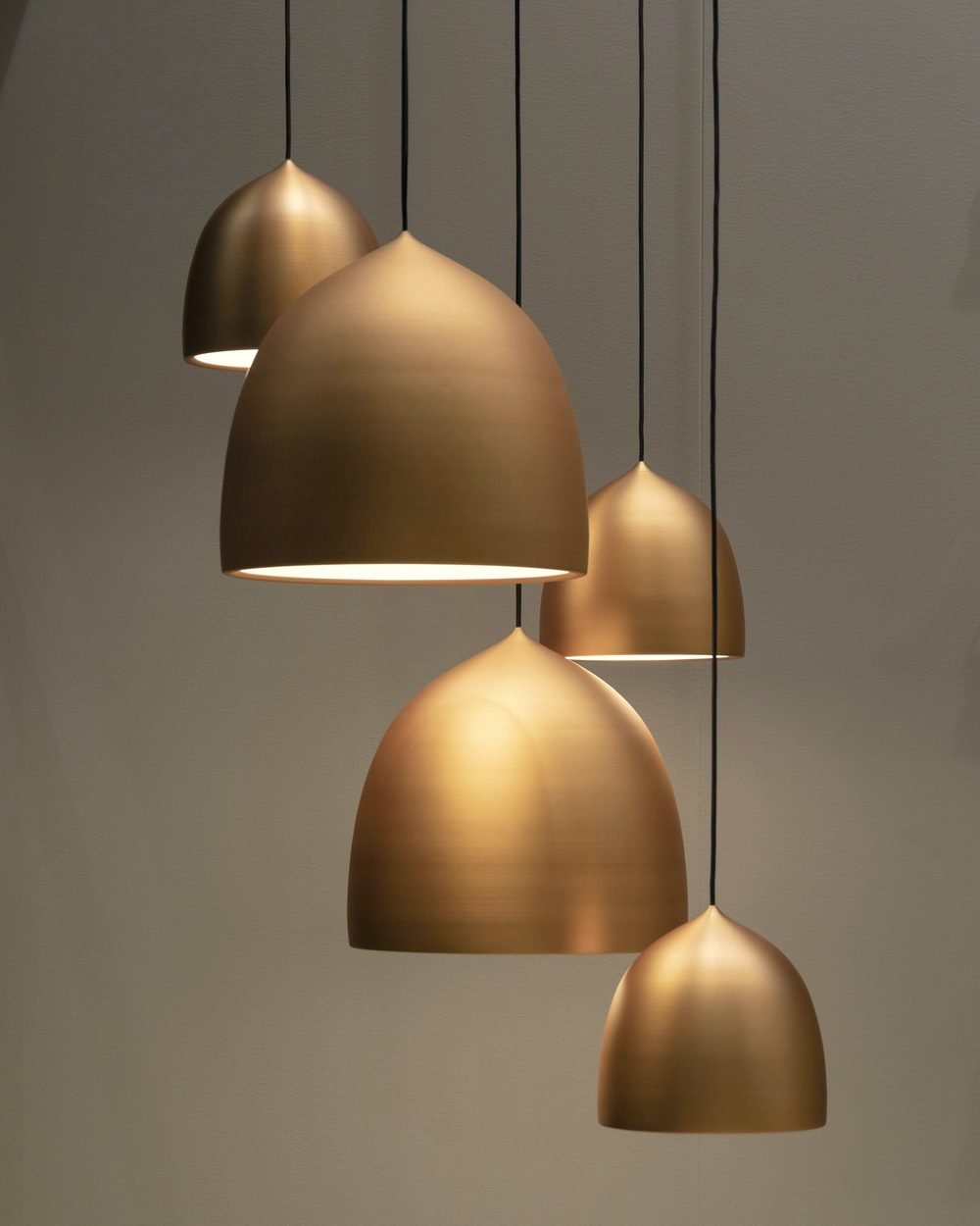 Sculptural brass pendant lights suspended in a warm interior